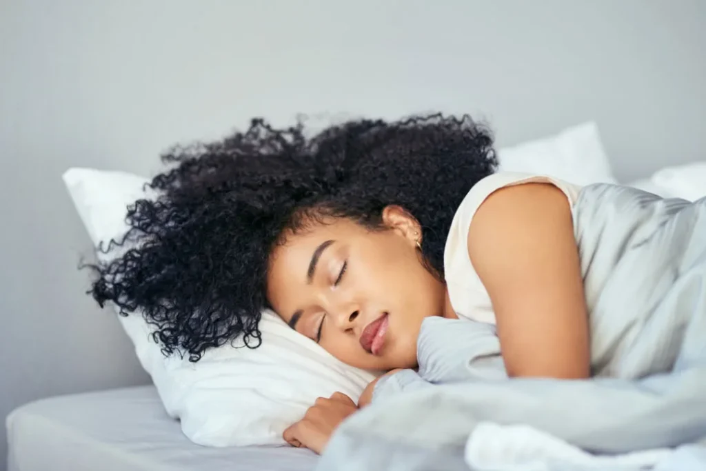 A brown girl sleeping on the bed.
