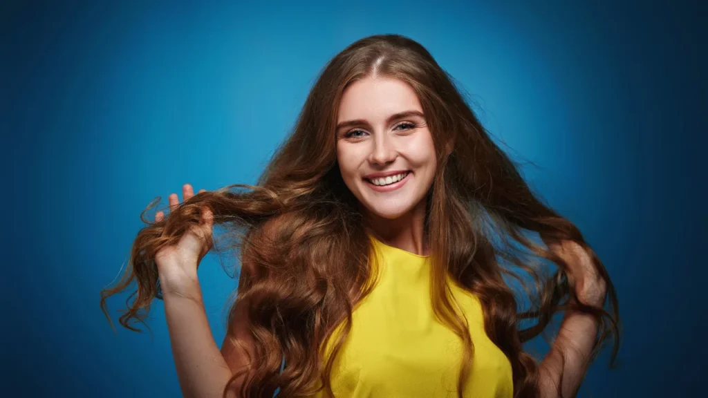 Happy young girl with long and strong hairs along with healthy and glowing skin